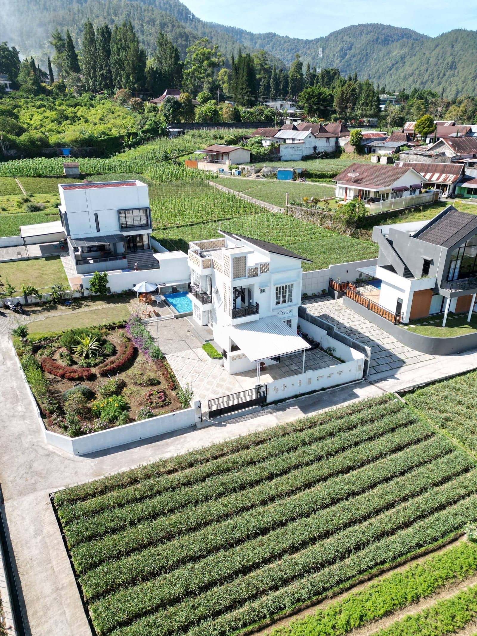 Aerial view of a modern farmhouse-style home surrounded by fields