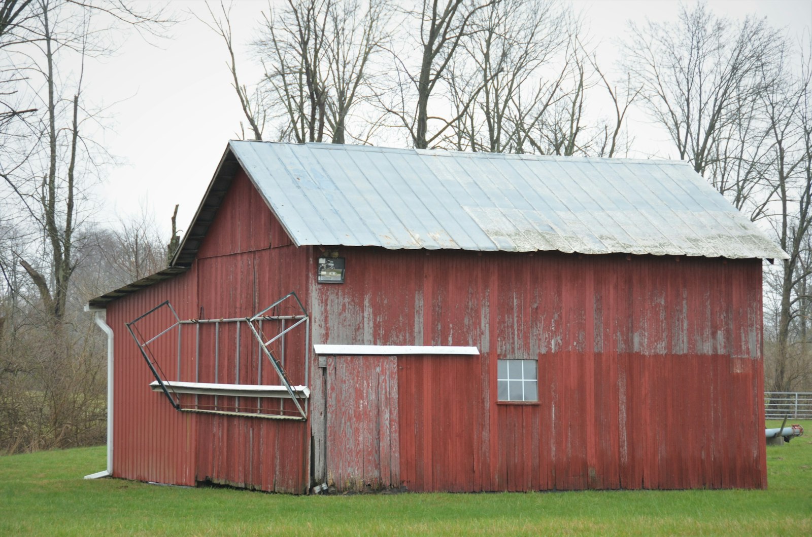 A finished agricultural machine shed with metal siding standing in a rural field