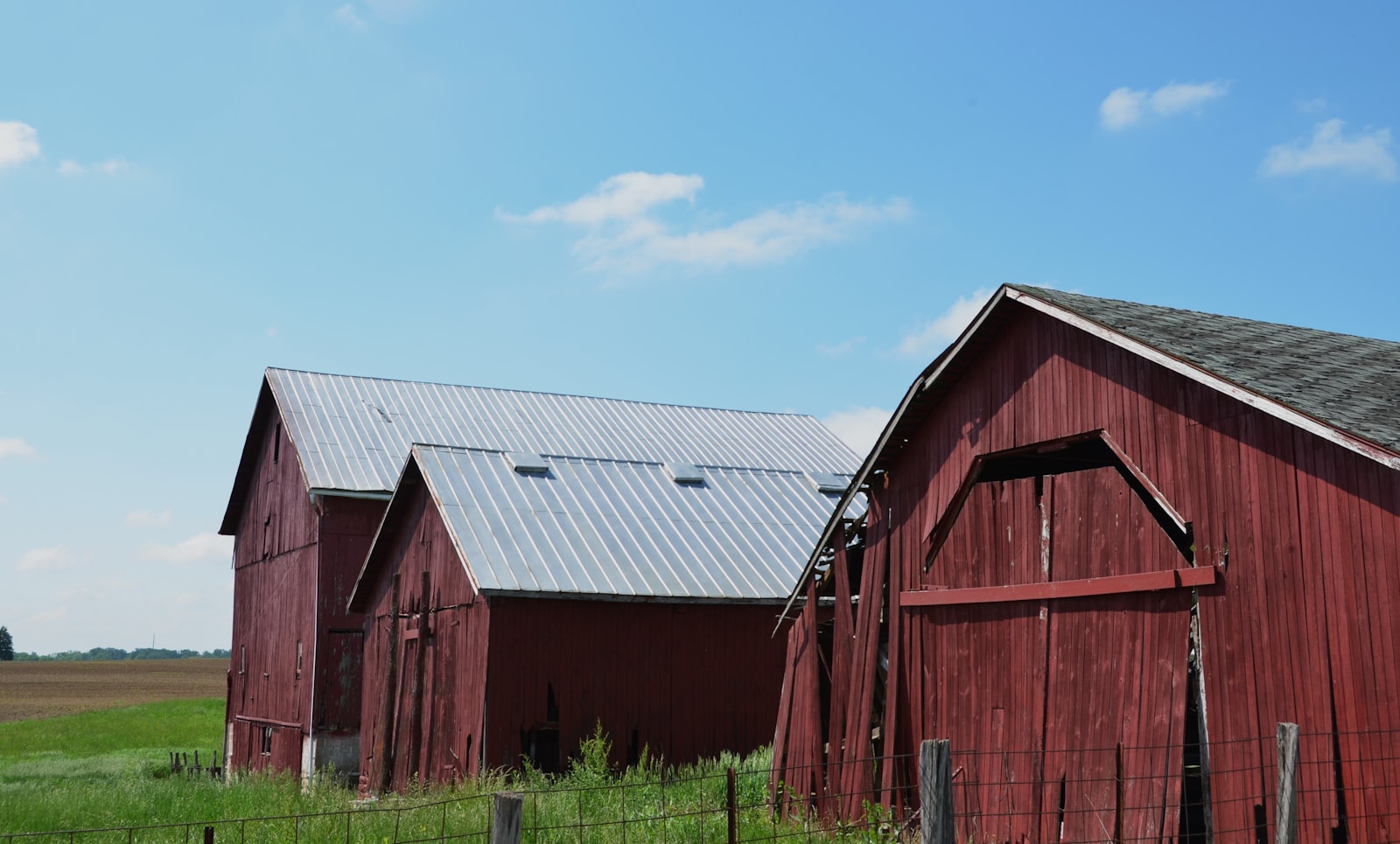 A pole barn style building with a metal roof on a rural lot