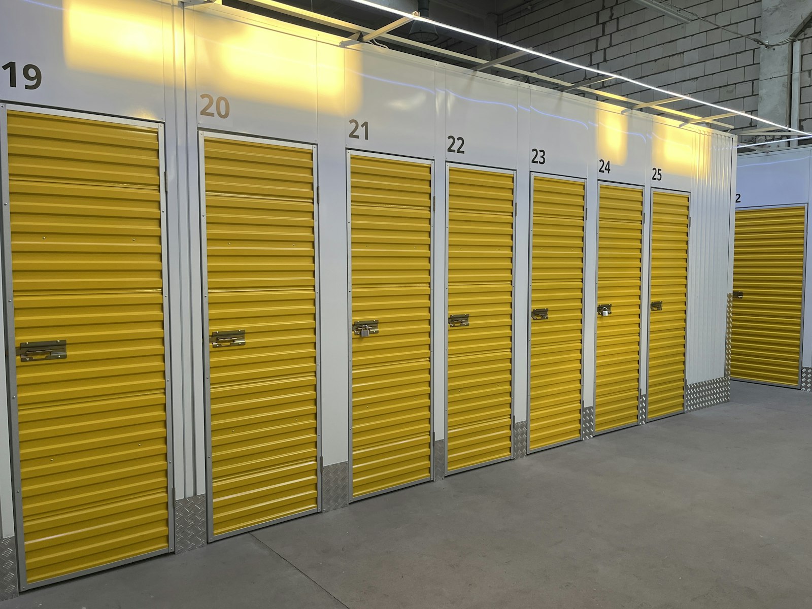 A row of self-storage units with bright yellow roll-up doors
