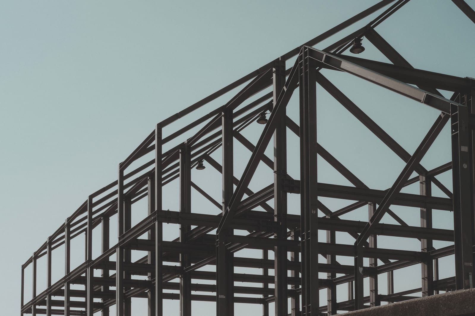 The bare steel frame of a building standing on a concrete slab, before walls or finishes are added