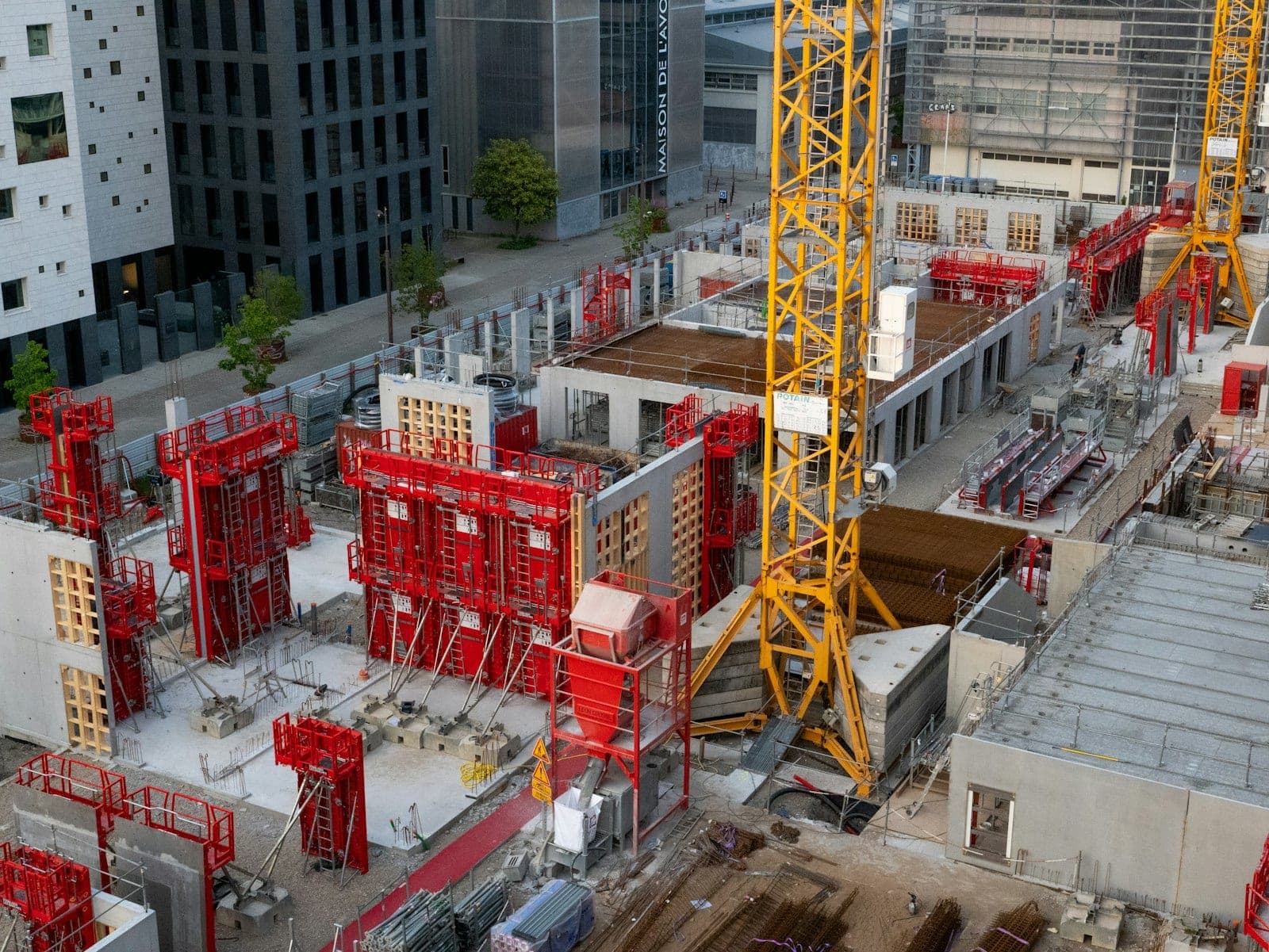 A busy steel building construction job site with equipment and machinery